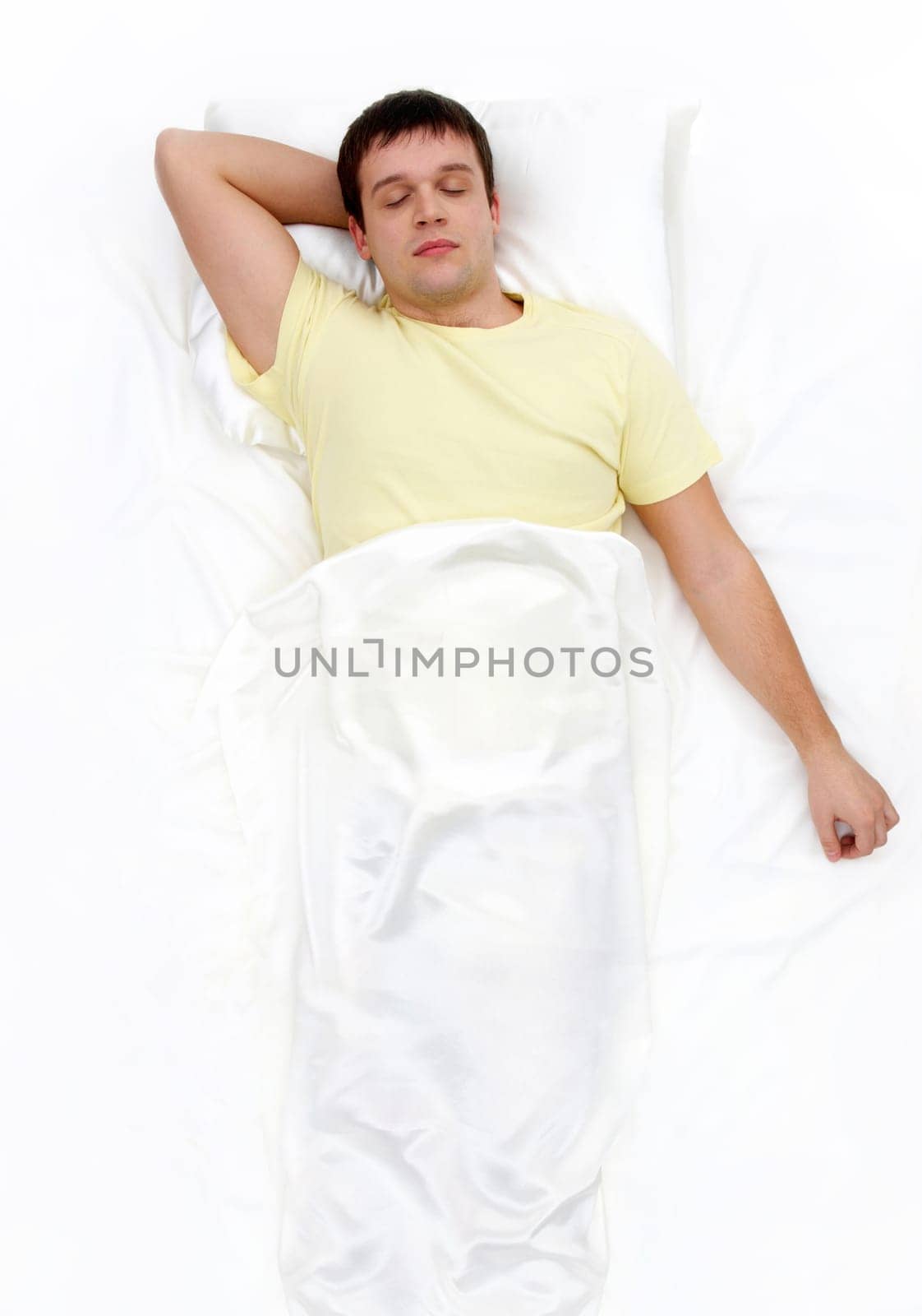 Above view of man with one hand under his head sleeping in cosy bed