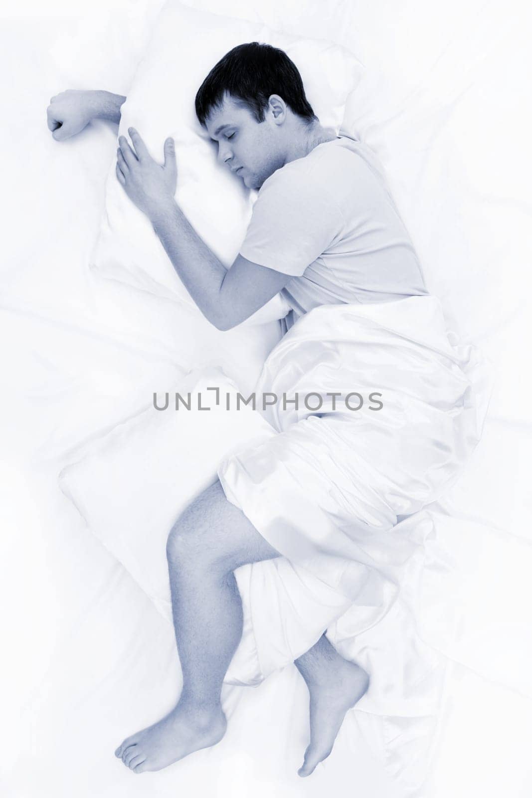 Black-and-white image of tired male having sweet dream at night