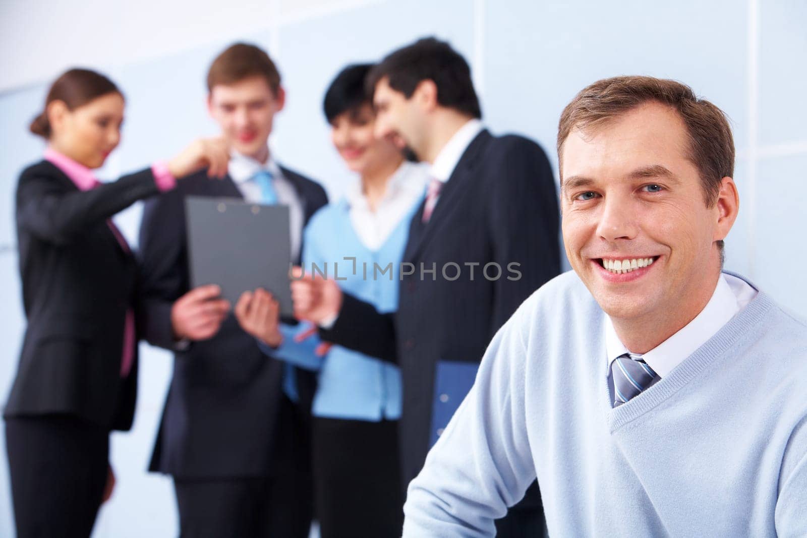 Photo of happy man looking at camera in working environment