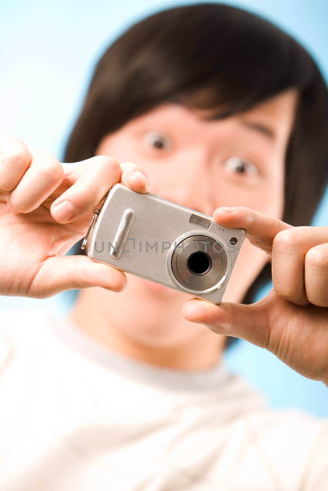 Image of photo camera in surprised male hands after making a shot