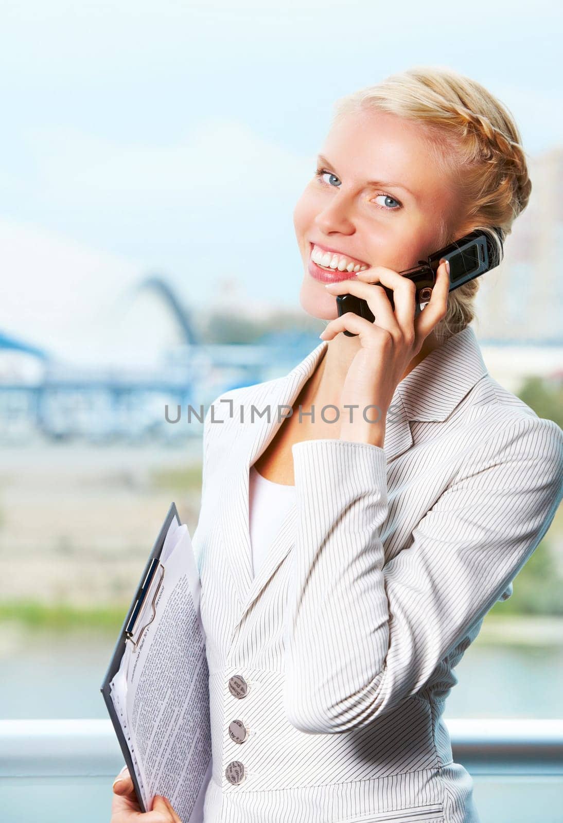 Portrait of elegant businesswoman looking at camera while speaking on the phone