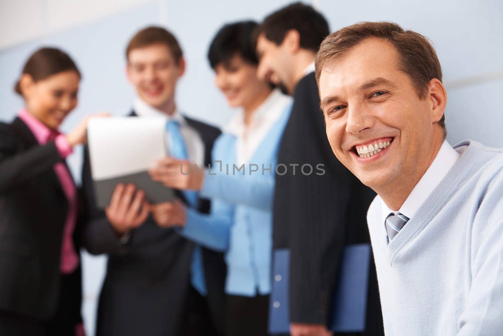 Photo of happy man looking at camera in working environment