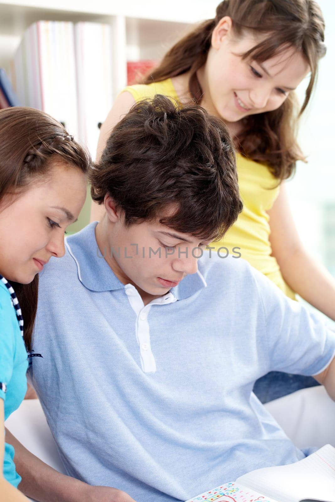 Three teenagers reading something together