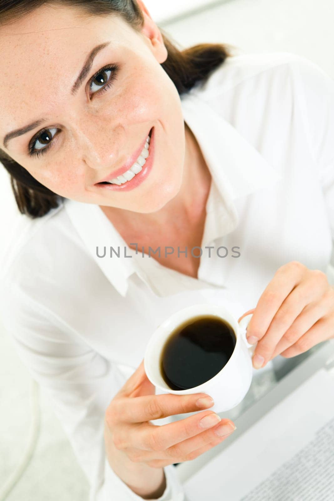 Close-up of business ladys face having coffee break and looking at camera with smile