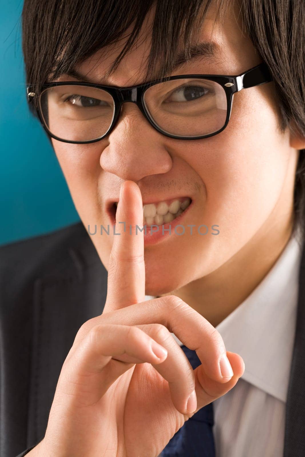 Portrait of young businessman with the finger near mouth