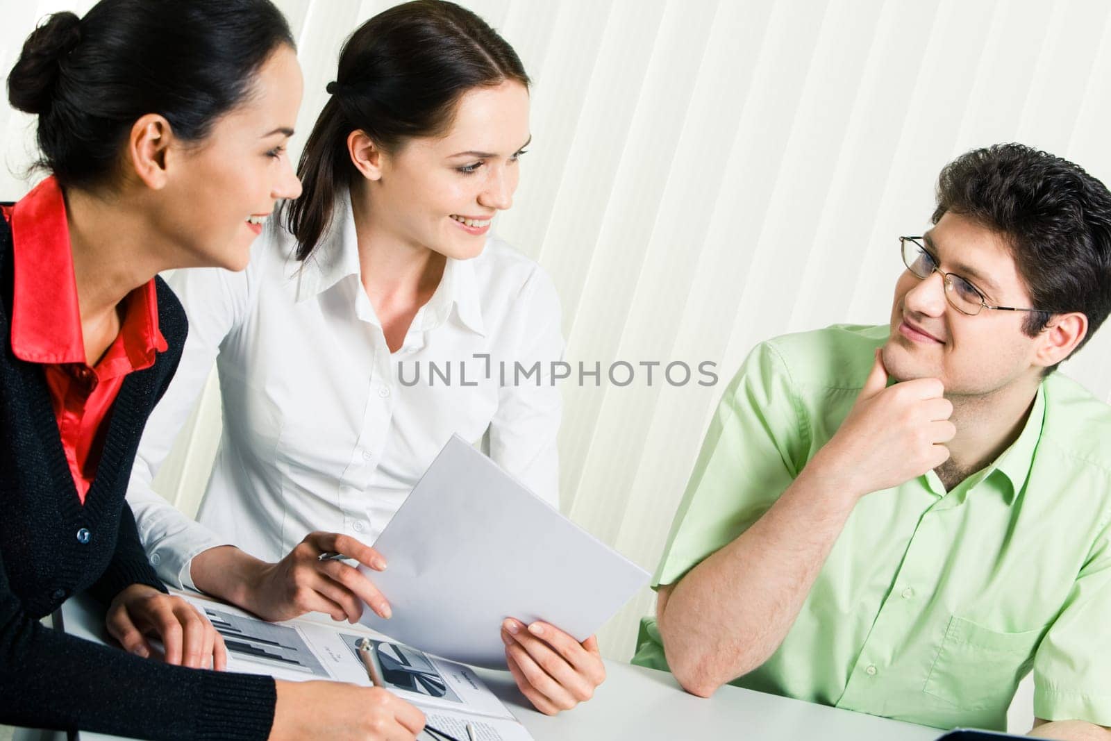 Portrait of three colleagues sitting in the office and sharing their ideas about business project