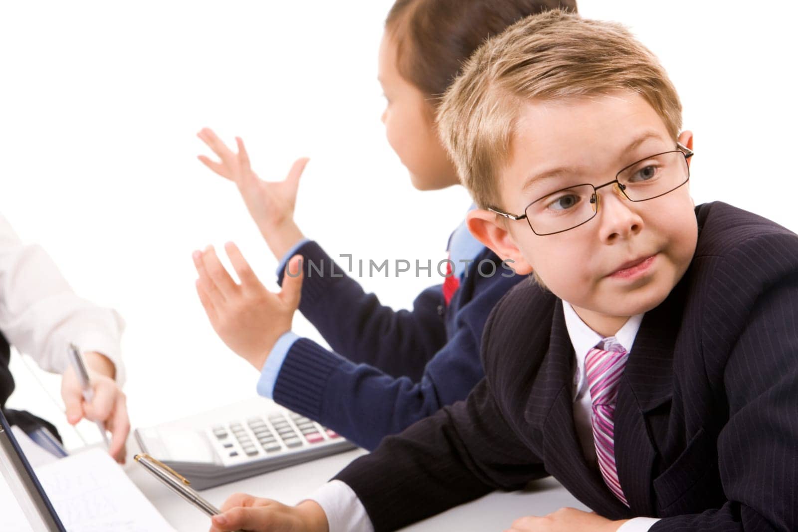 Photo of serious boy elegantly dressed looking aside with communicating girl at background