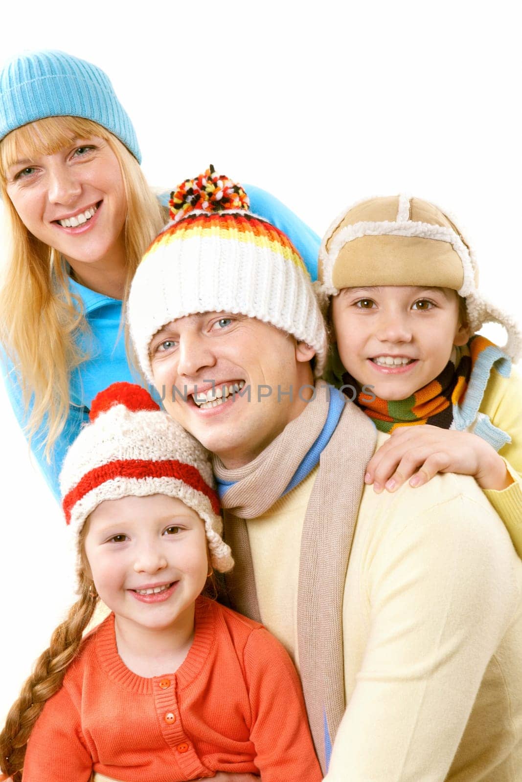 A happy family of four in warm clothes embracing