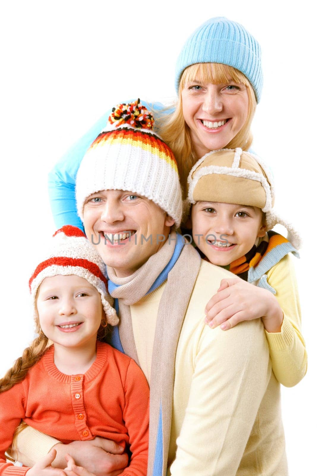 A family of four in winter clothes smiling and looking at camera