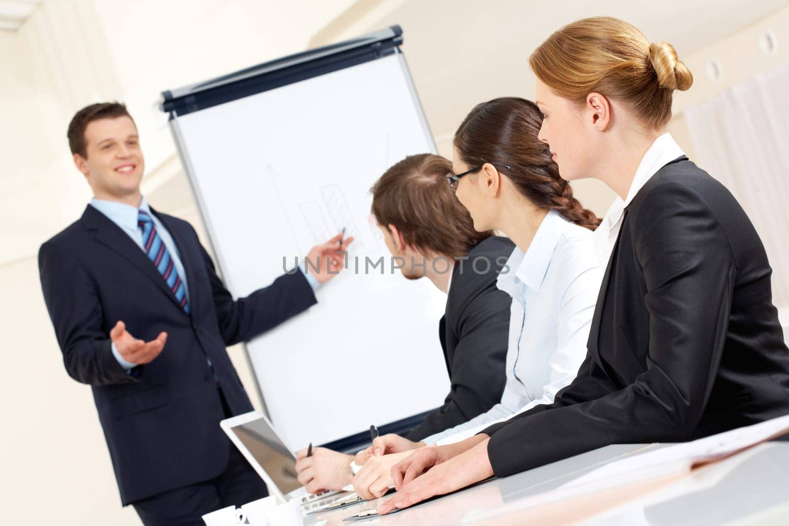 Photo of successful businessman sharing ideas by whiteboard with partners at presentation