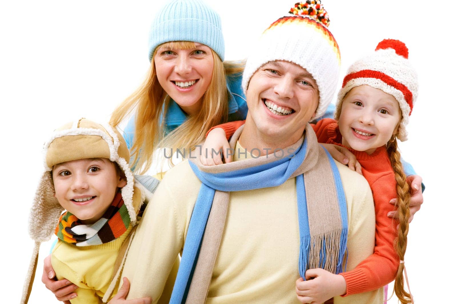 A cheerful family of four in winter clothes looking at camera