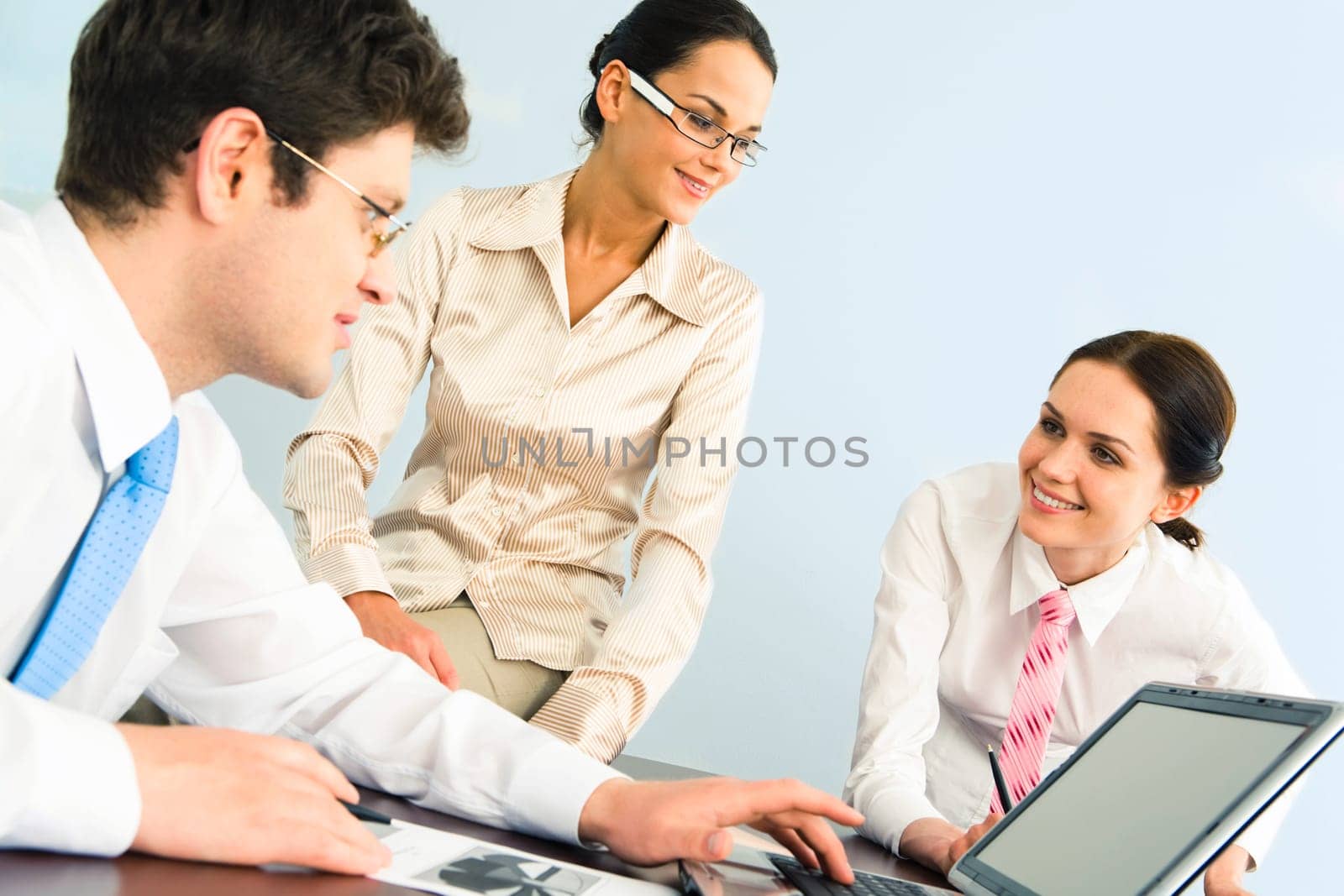 Business-team of three smiling people discussing new working ideas