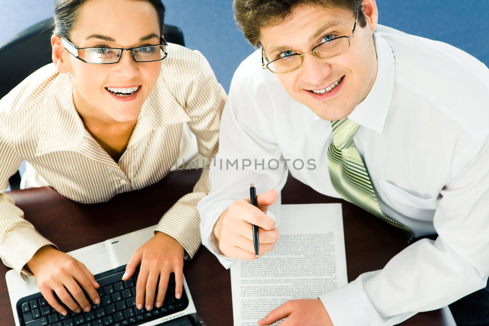 View from above of happy business team at work looking up at camera with smiles