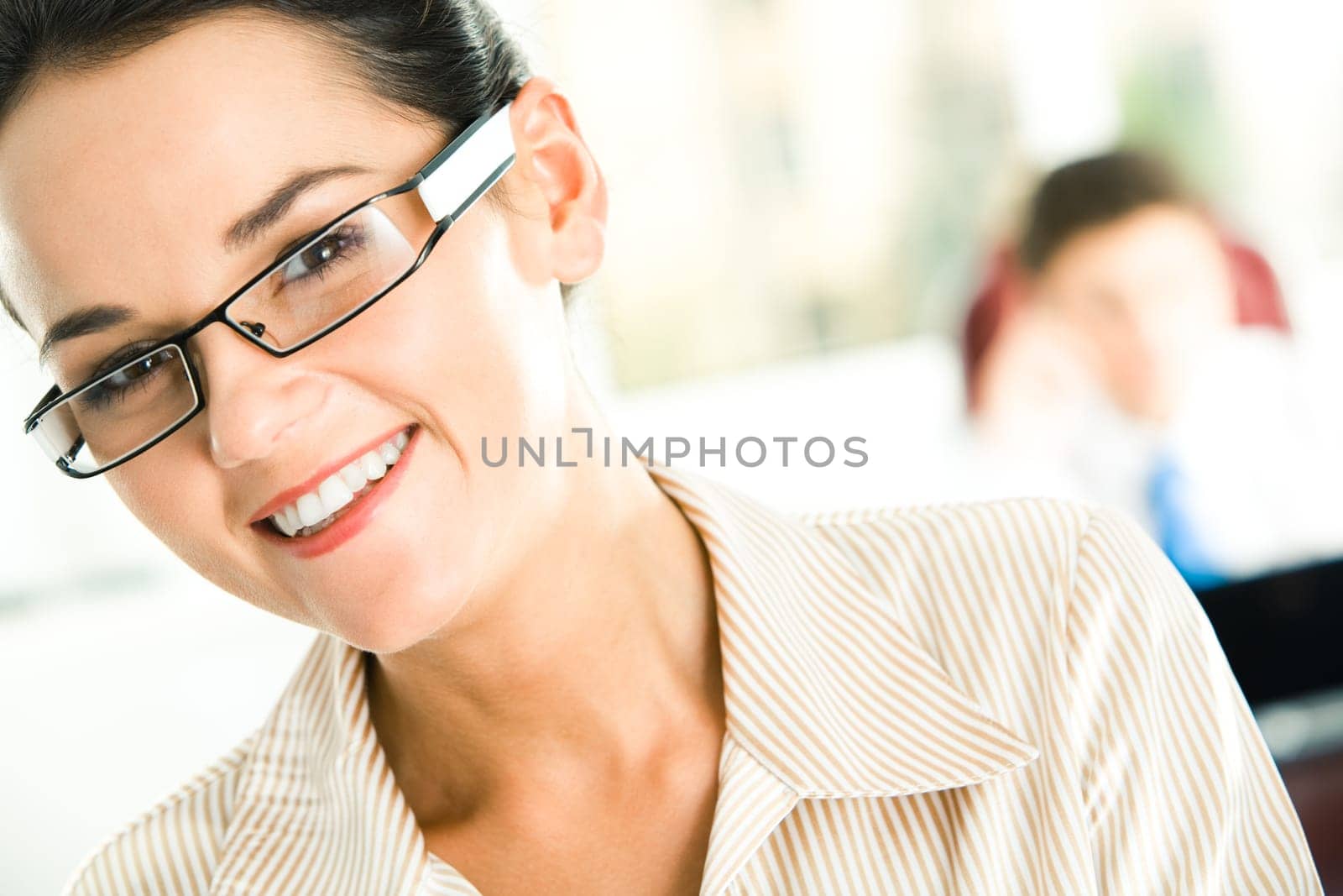 Portrait of happy female in glasses looking at camera with her head slightly aside