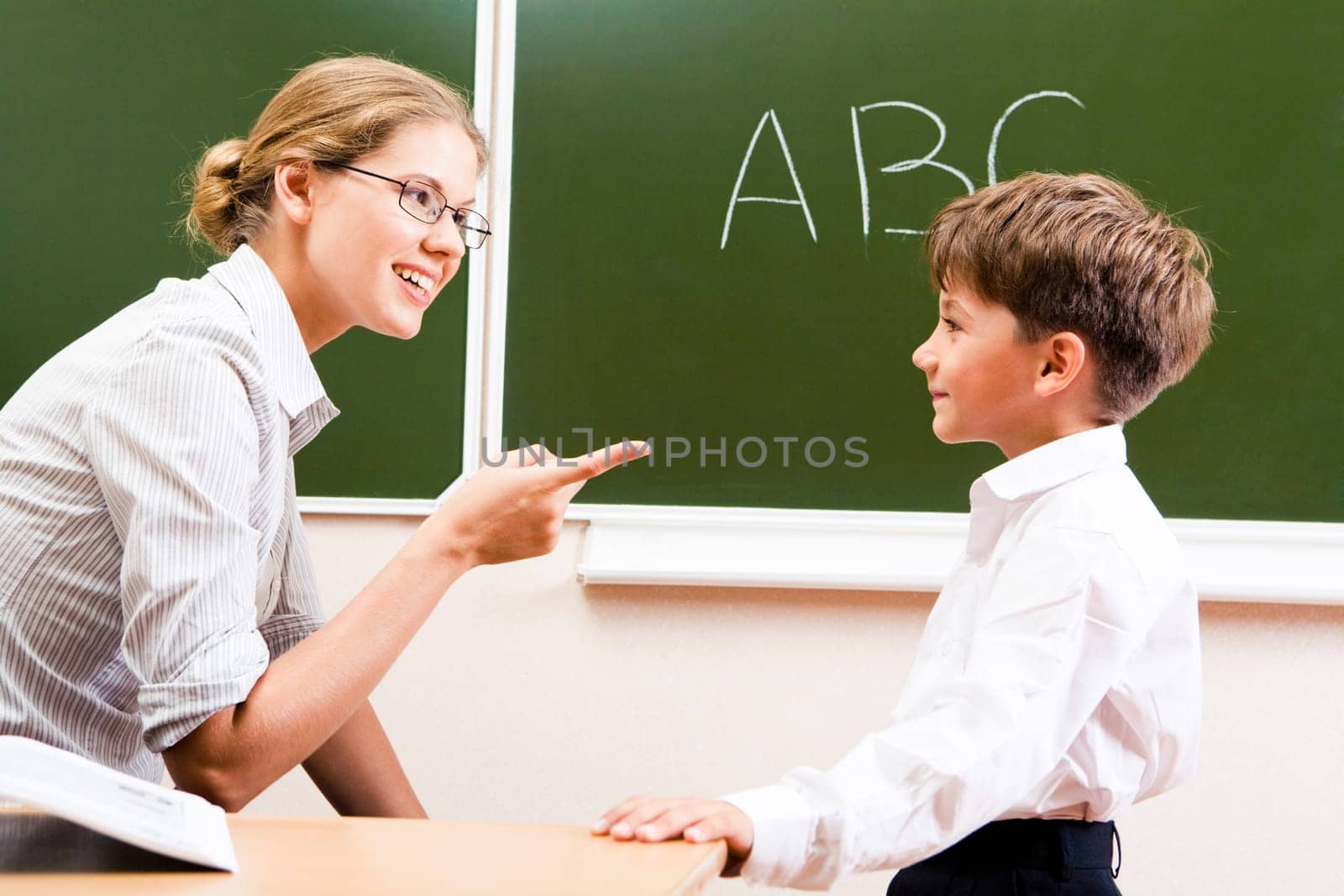 Portrait of confident teacher explaining grammar to schoolchild who looking at her attentively