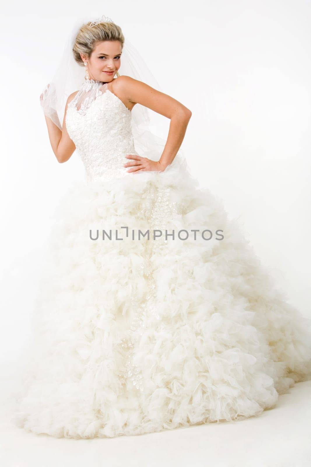 Image of elegant bride in fashionable white wedding gown posing before camera