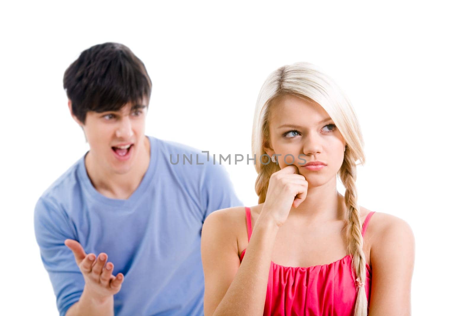 Sad woman with pensive expression touching her face on background of displeased man