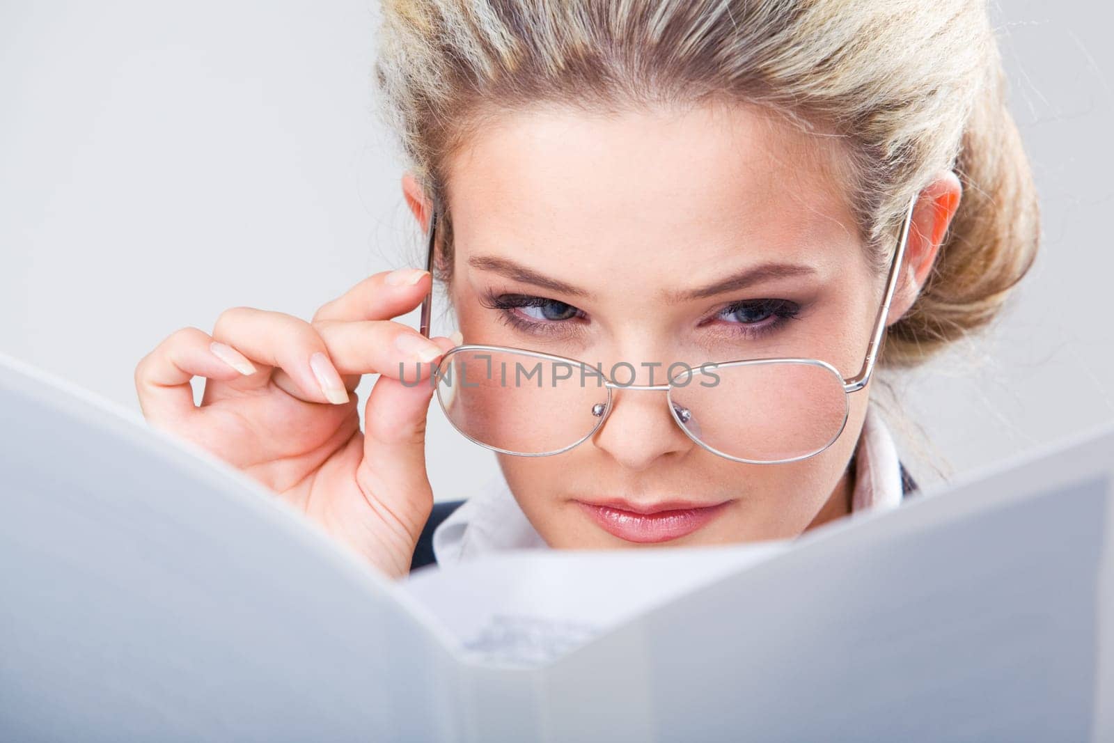 Close-up of businesswoman reading something through her glasses
