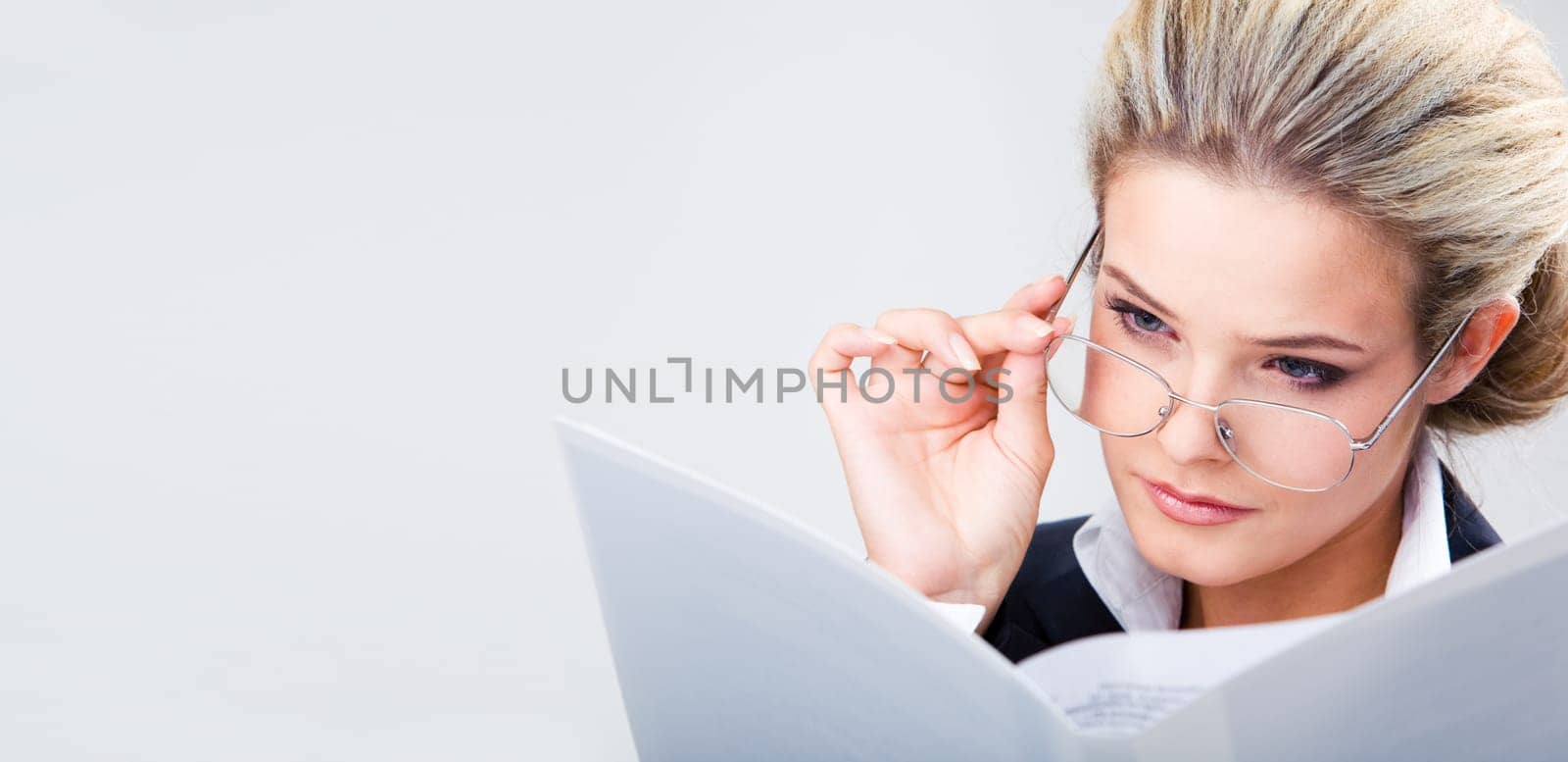 Photo of confident business lady wearing glasses and looking at plan seriously