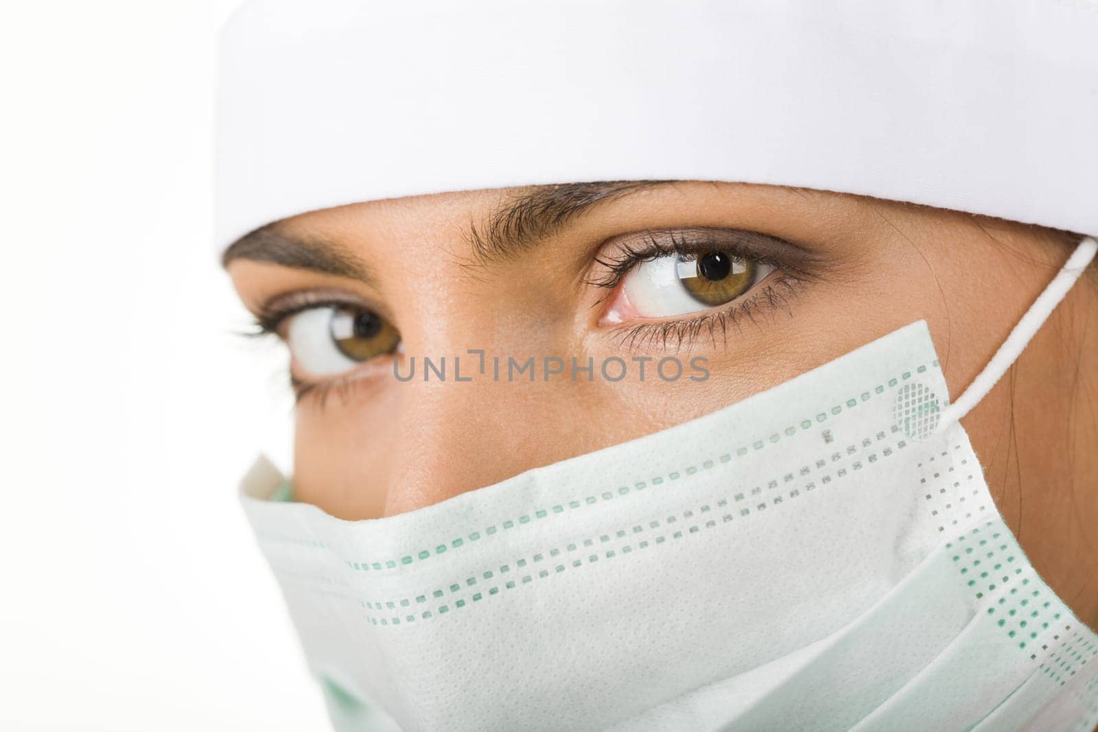 Close-up of pretty assistant wearing mask looking at camera