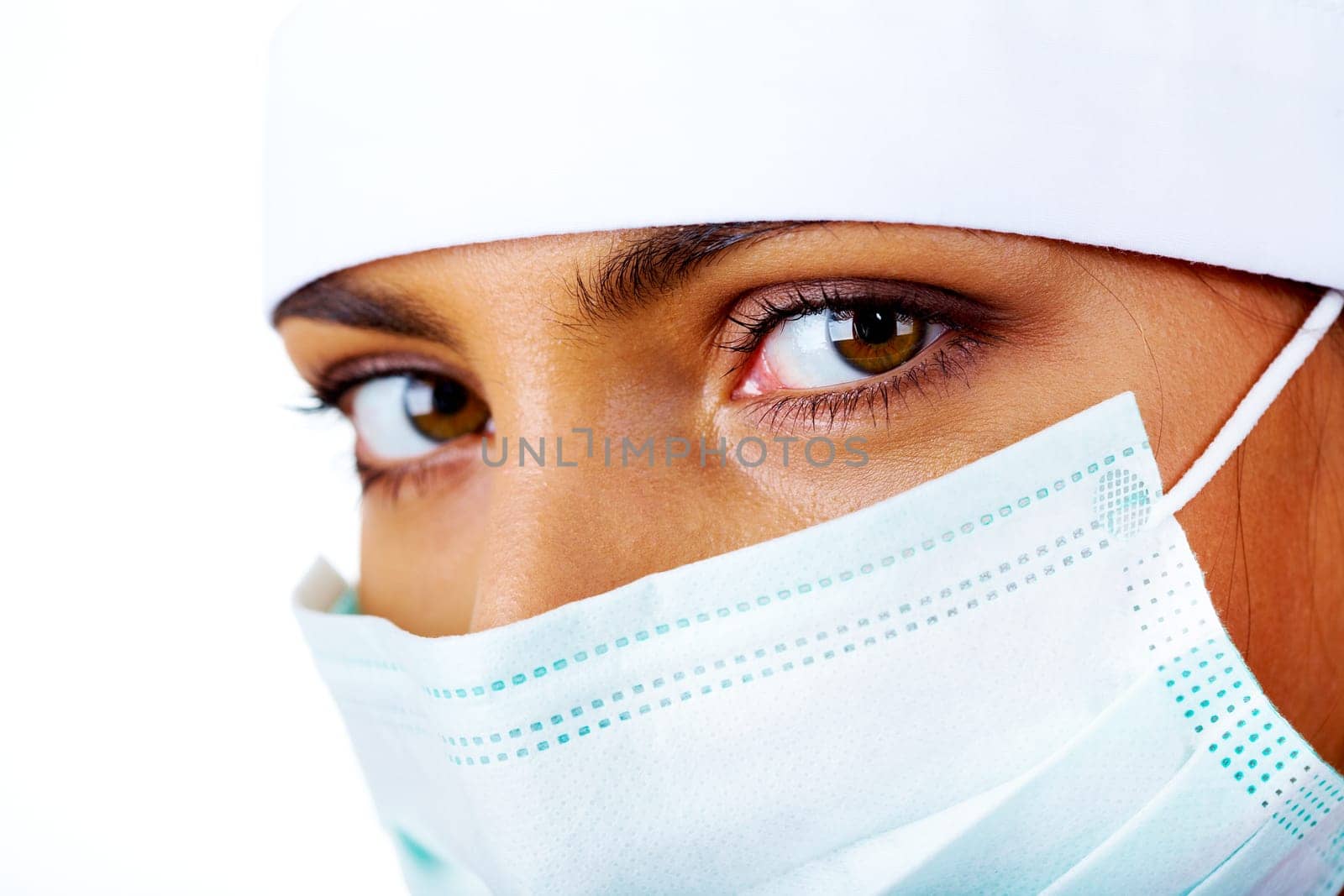 Close-up of pretty assistant in mask looking at camera