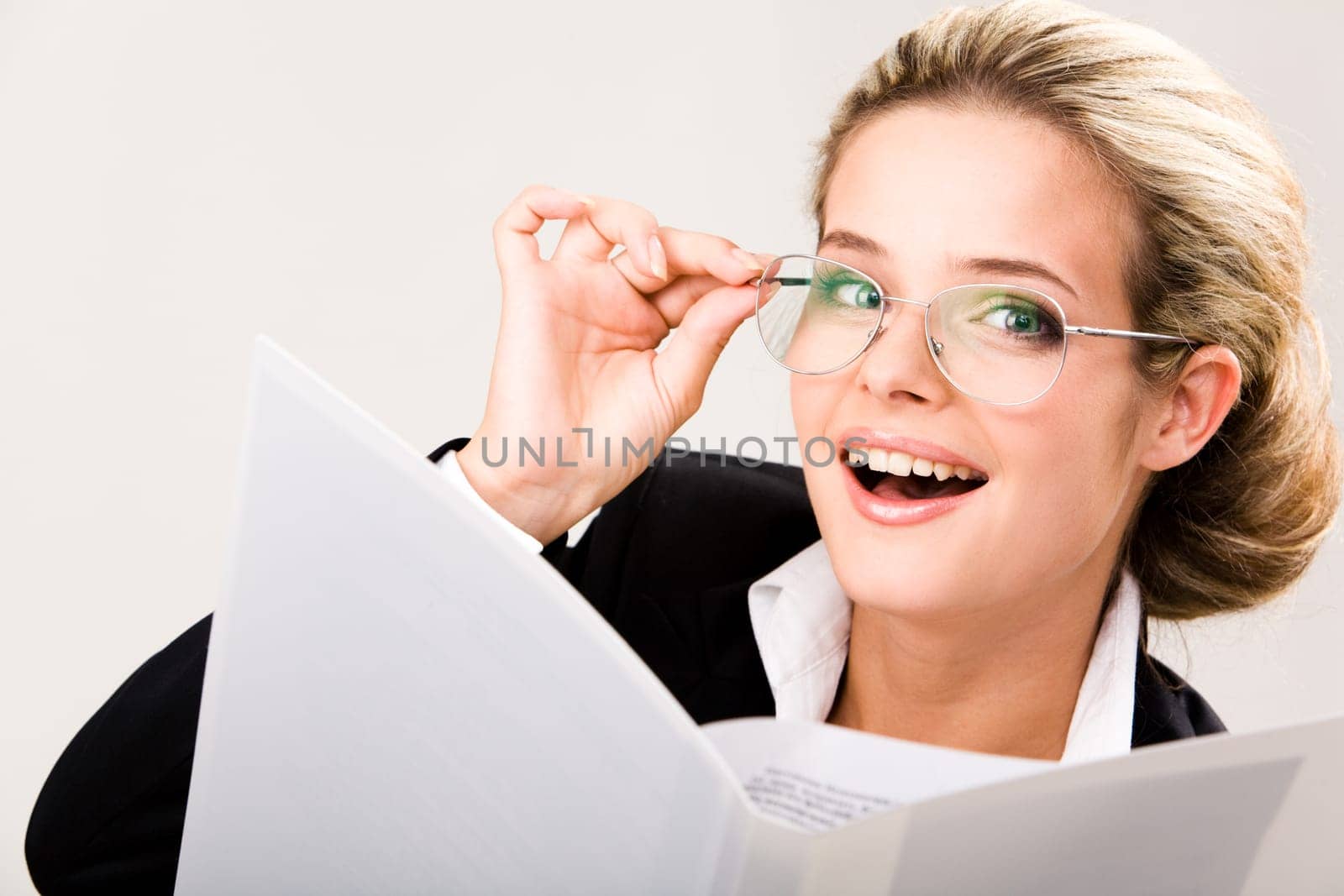 Portrait of confident female wearing glasses and looking at camera happily