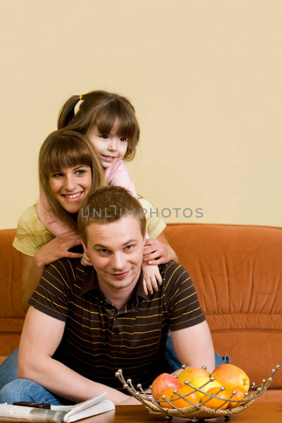 Happy mother and daughter keeping their heads on cute man and laughing