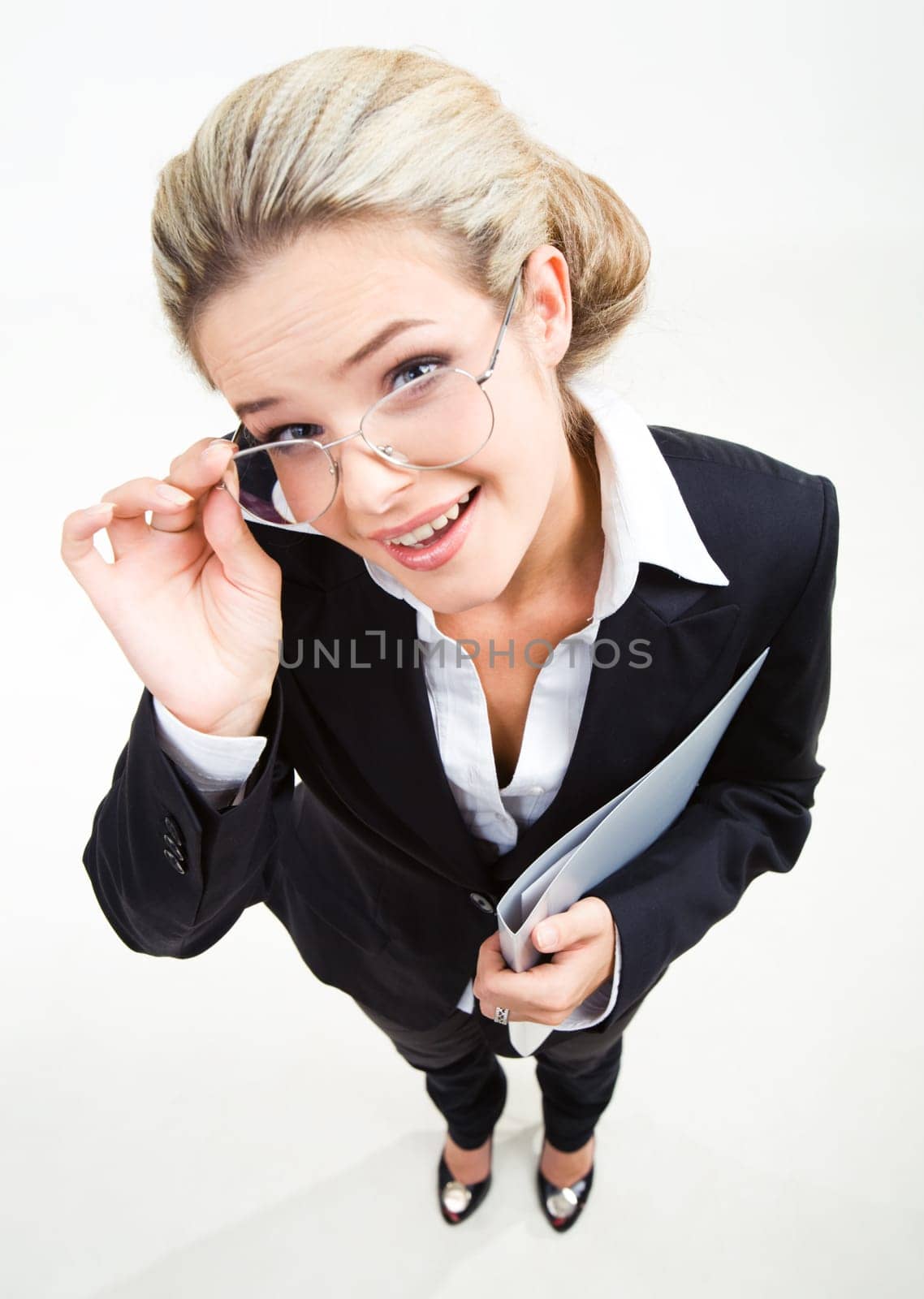 Above view of modern business woman wearing black suit and glasses and staring at camera with positive expression