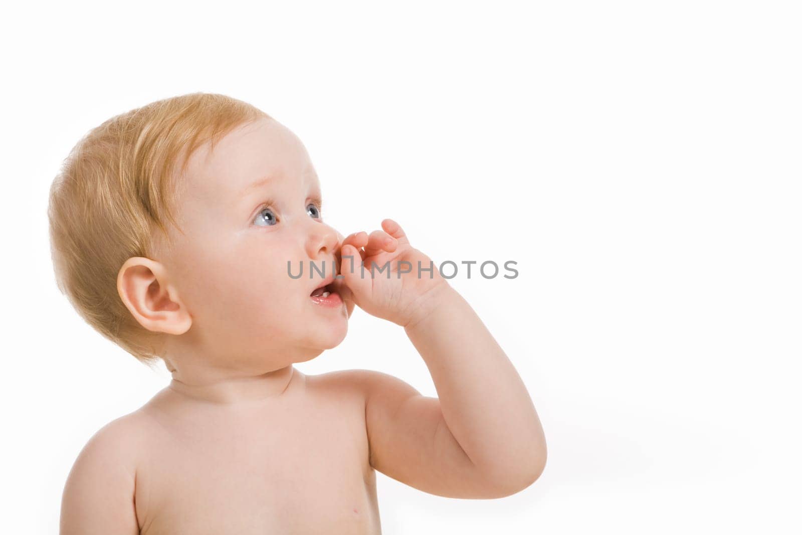 Portrait of cute little girl putting her finger to the mouth and looking aside