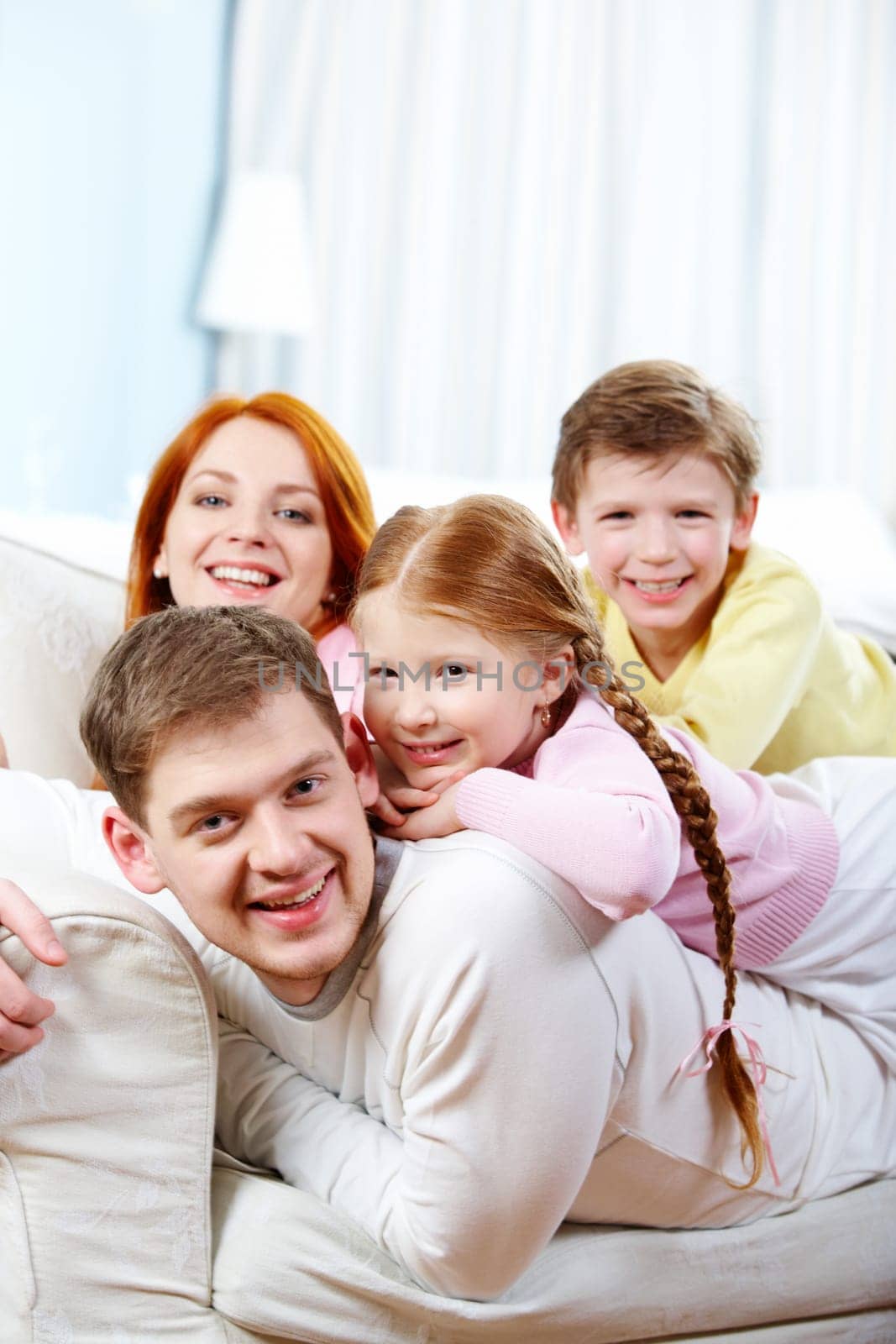 Portrait of happy parents and their children relaxing on the sofa at home