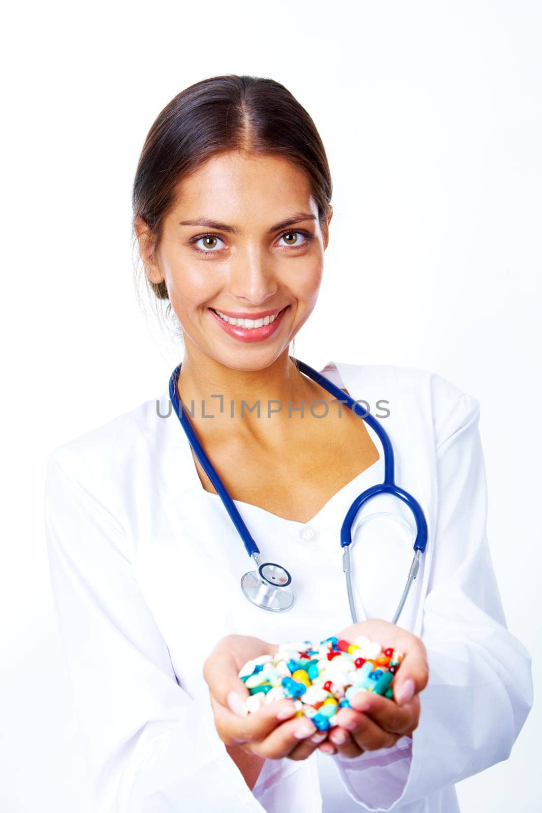 Portrait of happy pharmacist with handful of vitamins looking at camera