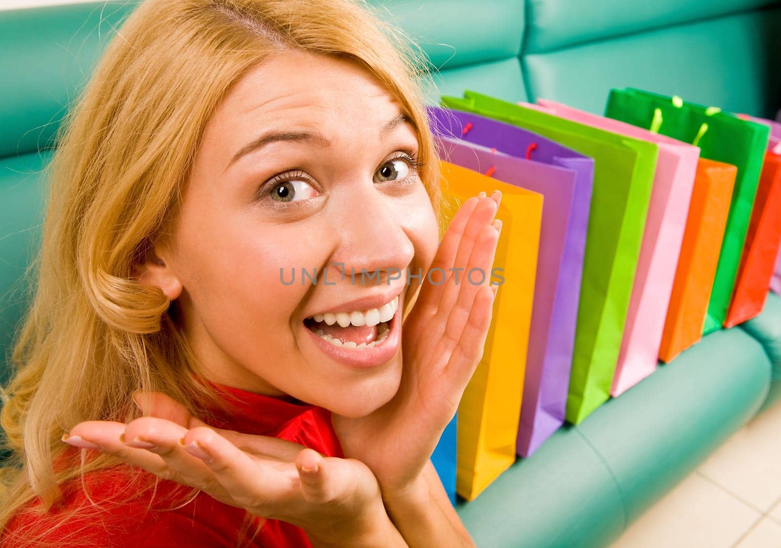 Portrait of woman being happy out of presents placed on sofa