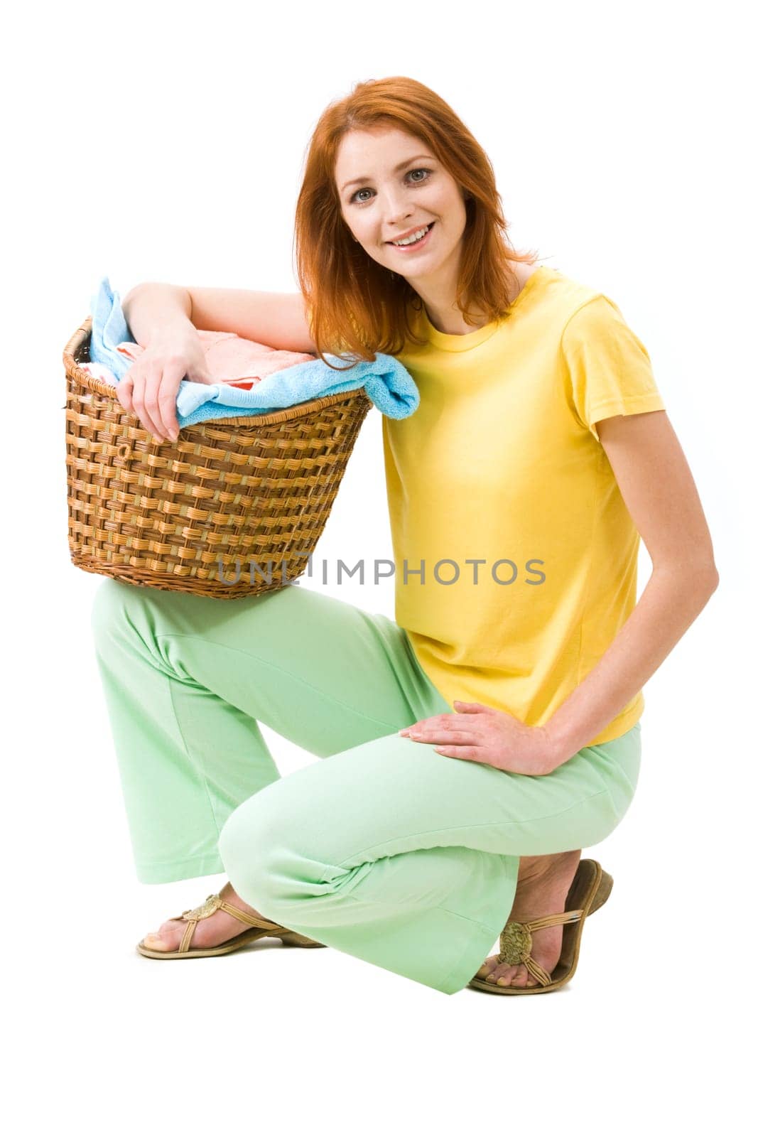 Portrait of young female with stack of colorful towels smiling to camera