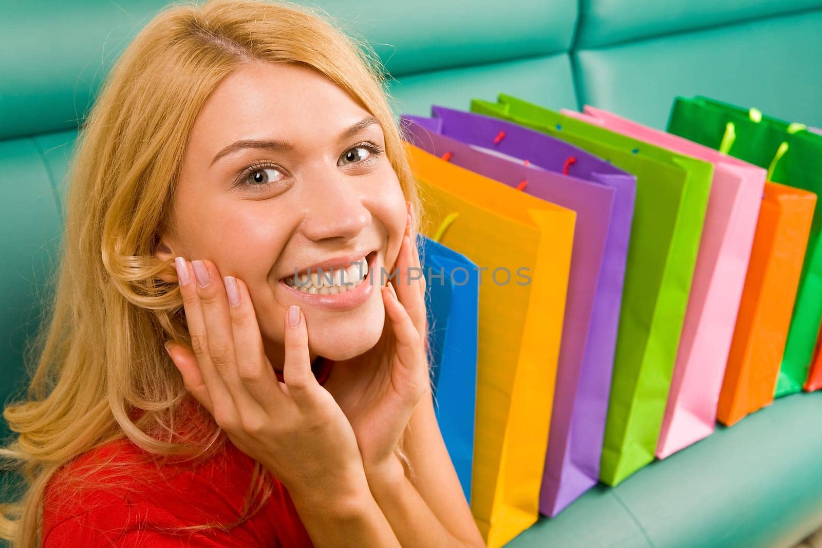 Portrait of woman being happy out of presents placed on sofa