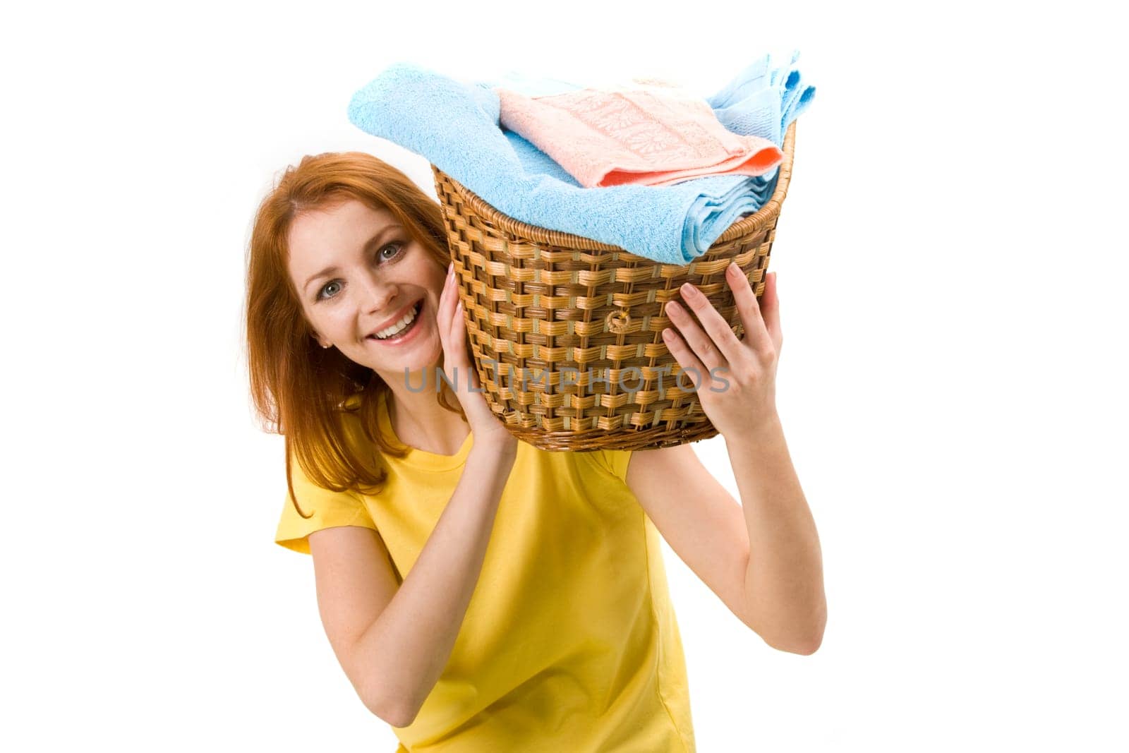 Portrait of young female holding basket full of colorful towels