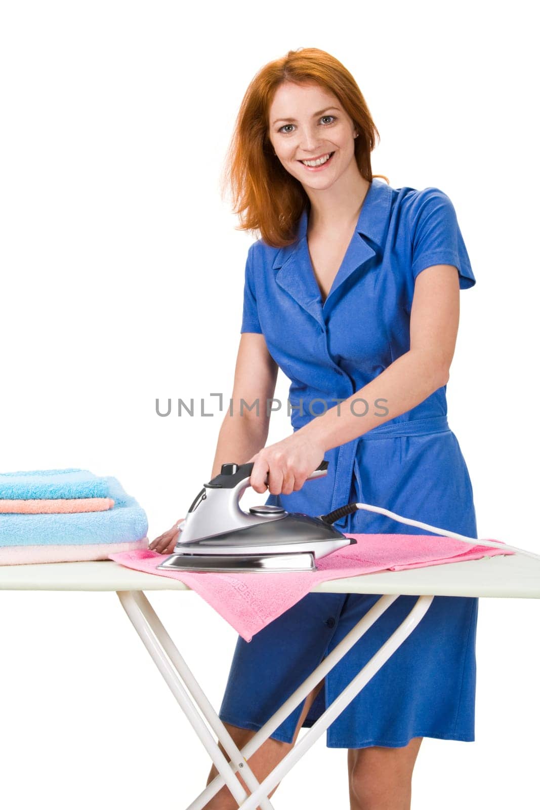 Portrait of young female ironing towels at home