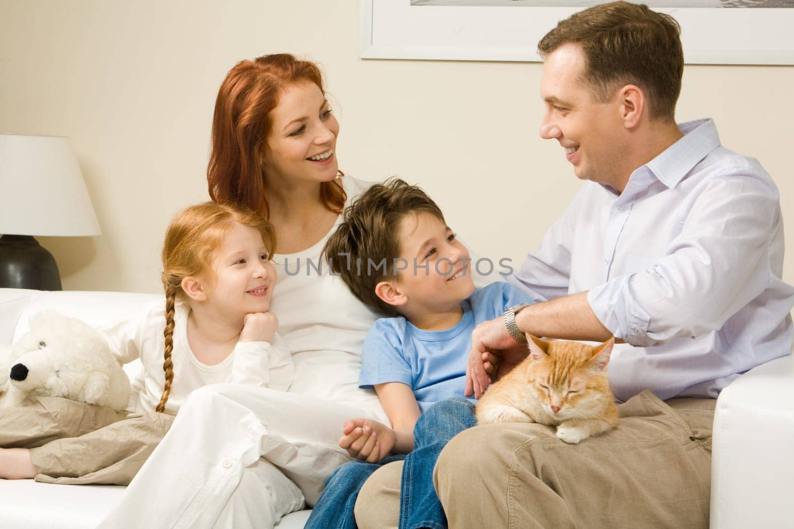 Friendly family members sitting on comfortable sofa and communicating at home