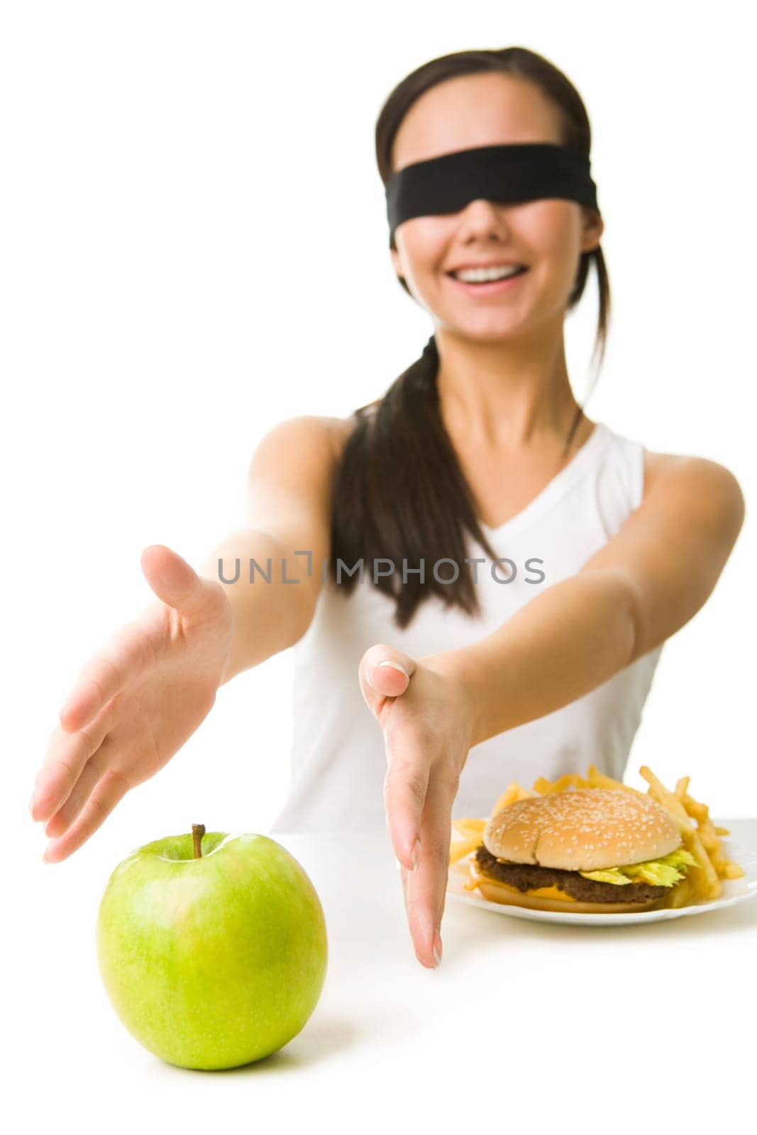 Portrait of young girl with her eyes folded stretching her arms towards green apple