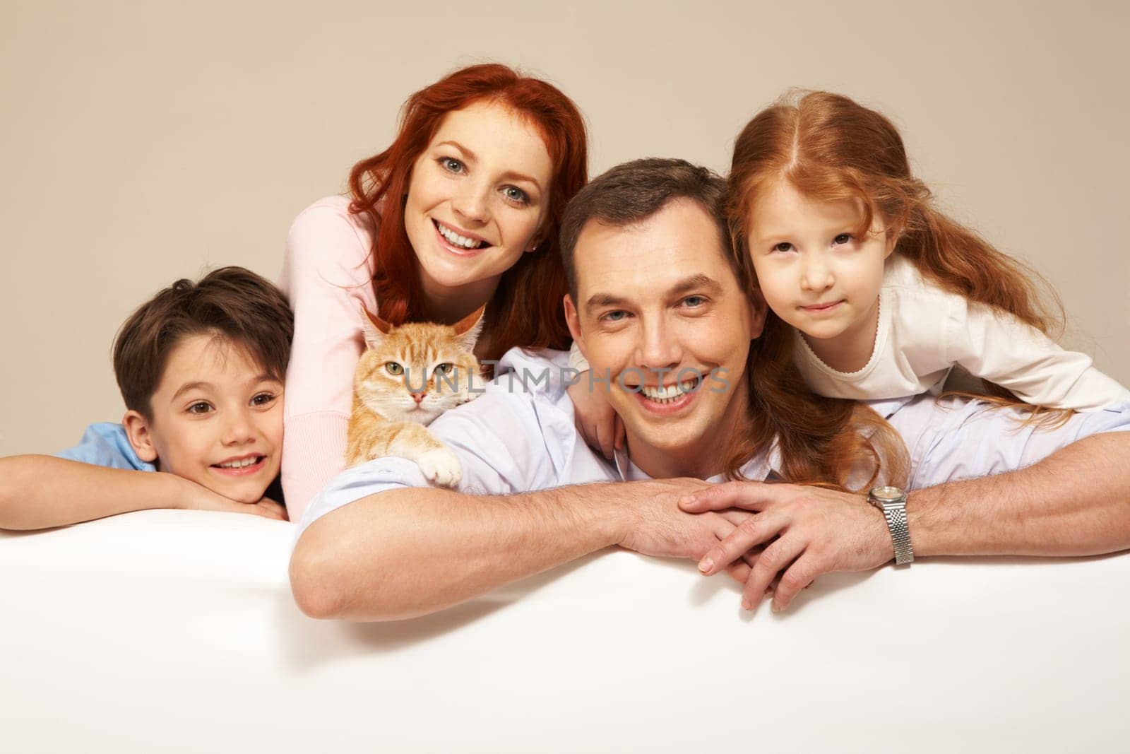 Happy couple and their two children smiling with pet among them