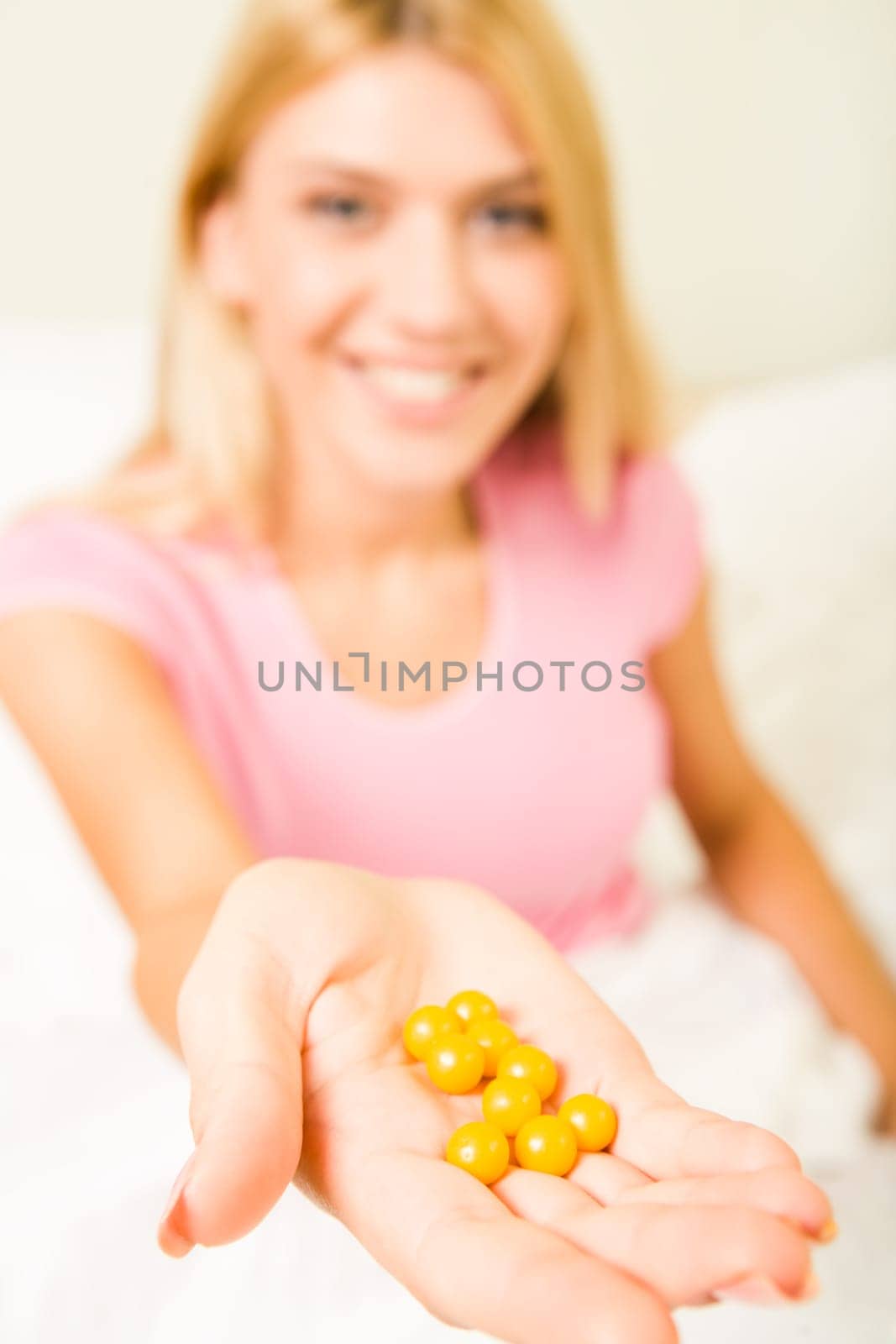 Close-up of females hand with yellow vitamins on it