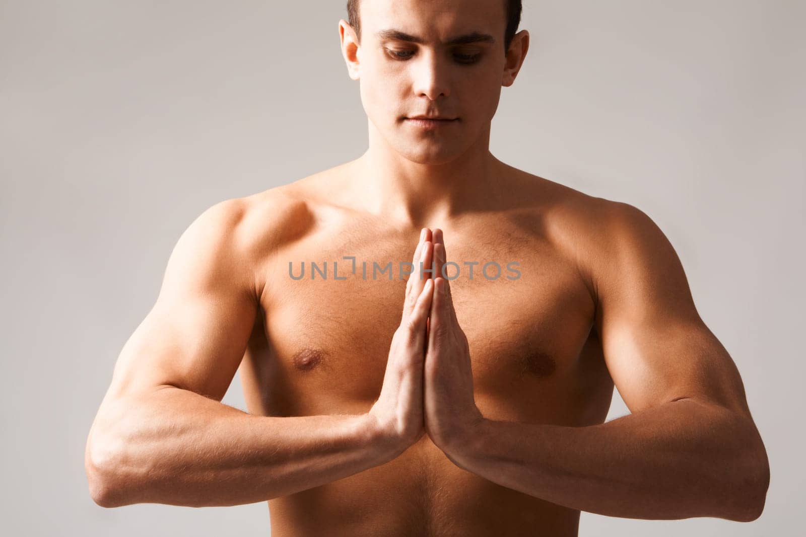 Image of shirtless man keeping his hands put together by chest