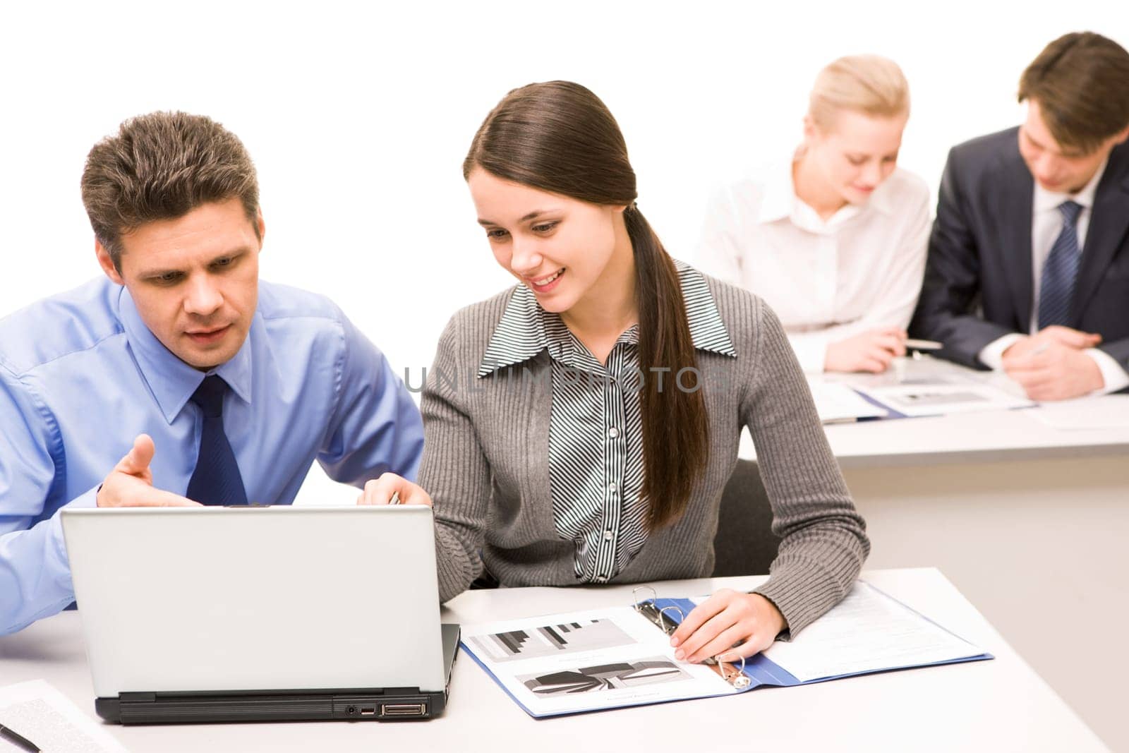 Cheerful partners looking at laptop monitor in working environment