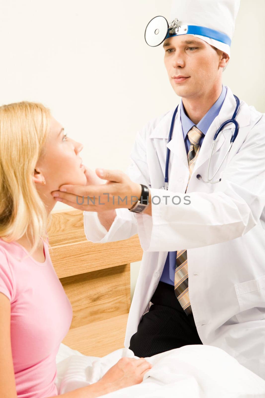 Portrait of young pretty woman sitting on bed and being examined by practitioner