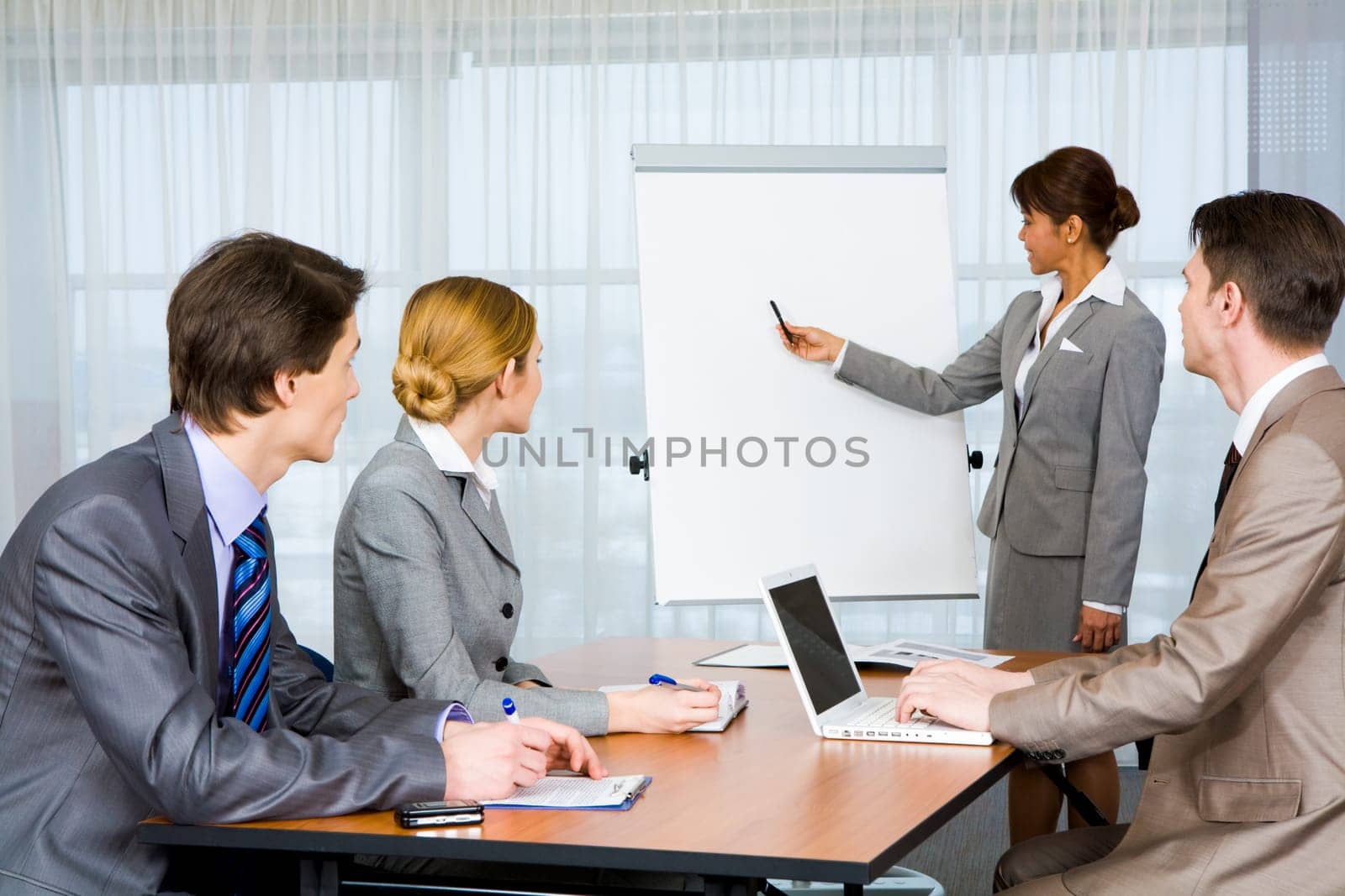 Photo of attentive business partners listening to smart teacher presenting new project