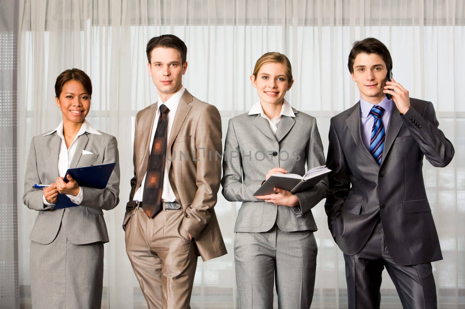 Elegant business people standing in line and looking at camera