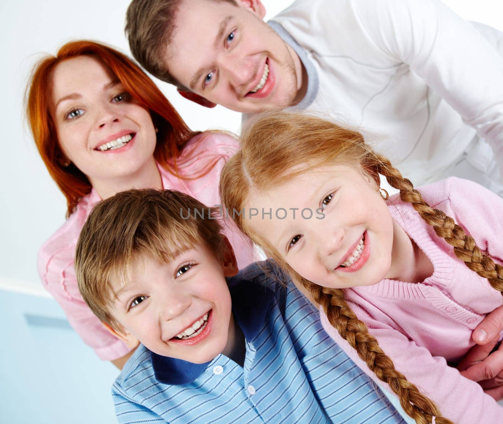 Happy couple and their two children smiling while looking at camera