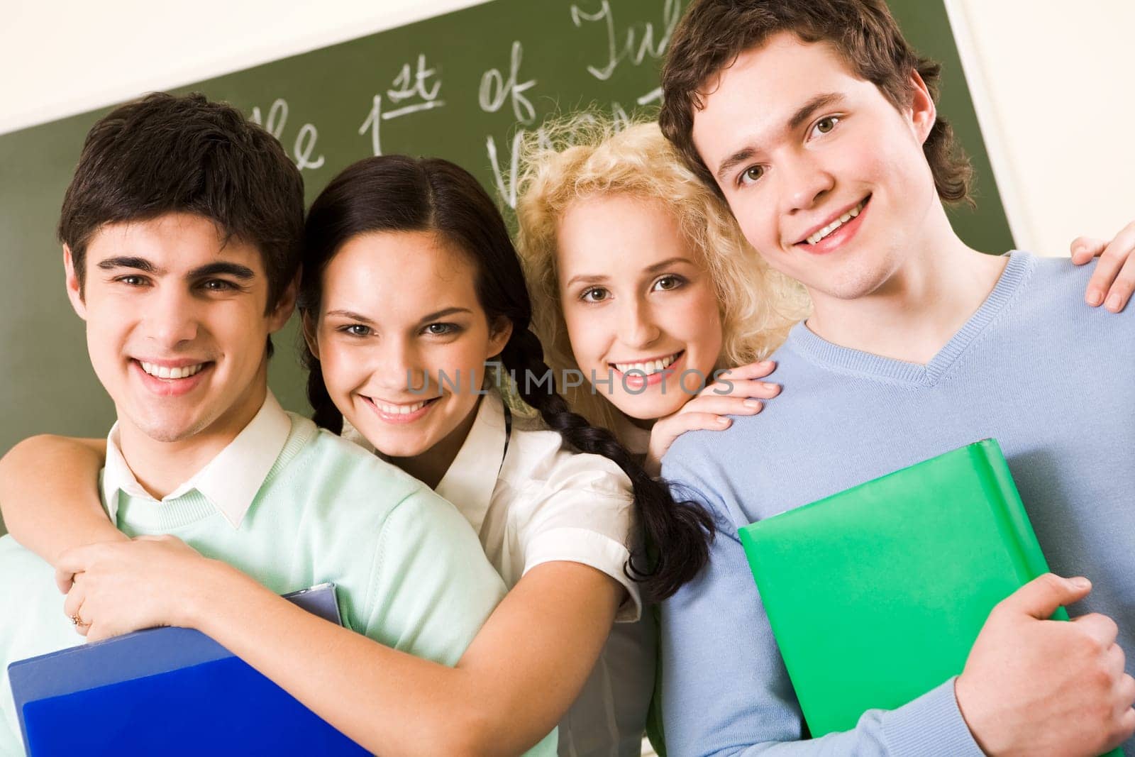 Portrait of happy students standing in line and looking at camera with smiles