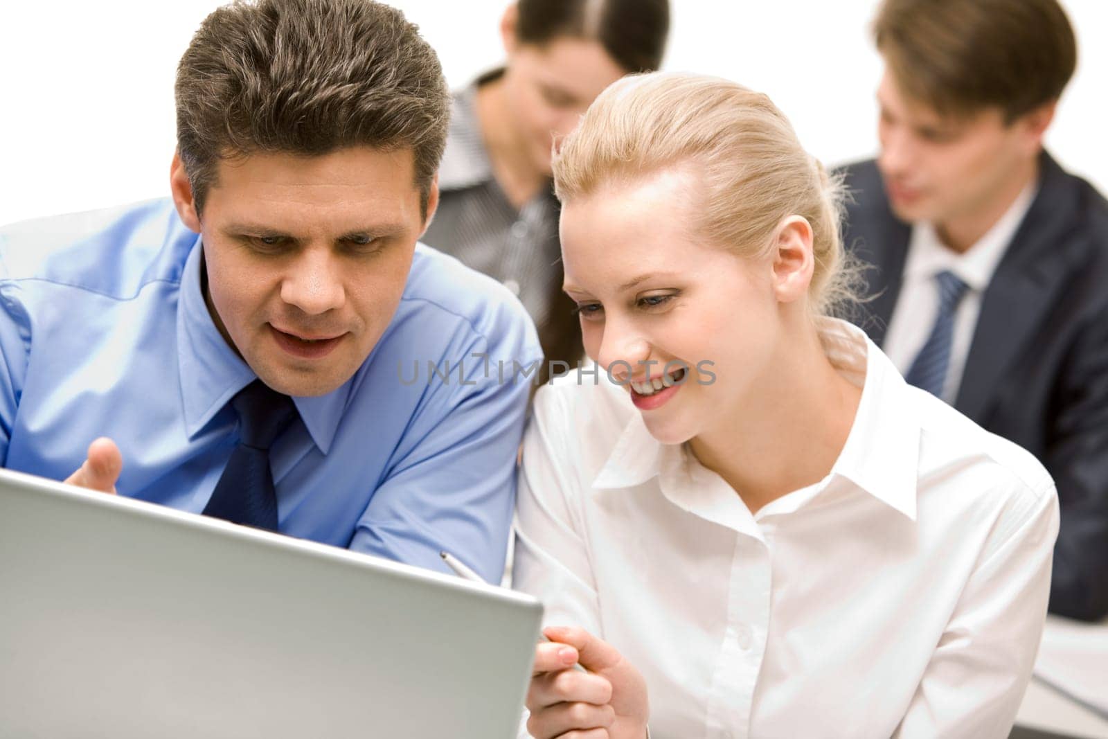 Business partners looking at laptop monitor in working environment