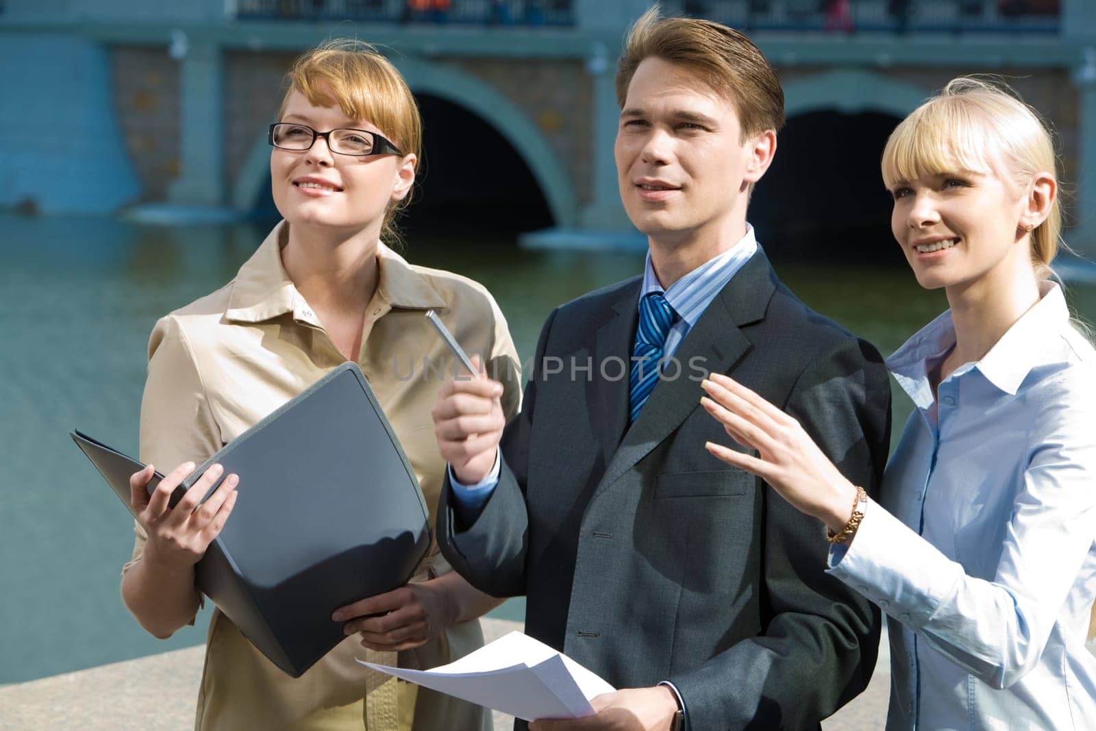 Portrait of confident partners pointing at something outdoors and looking at it