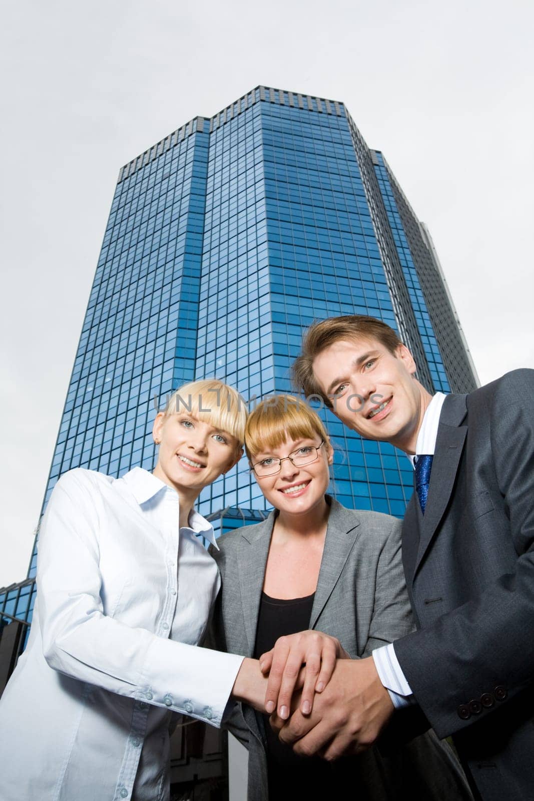 Portrait of friendly people putting their hands on top of each other